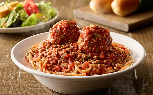 Lunch spaghetti and meatballs with salad and breadsticks